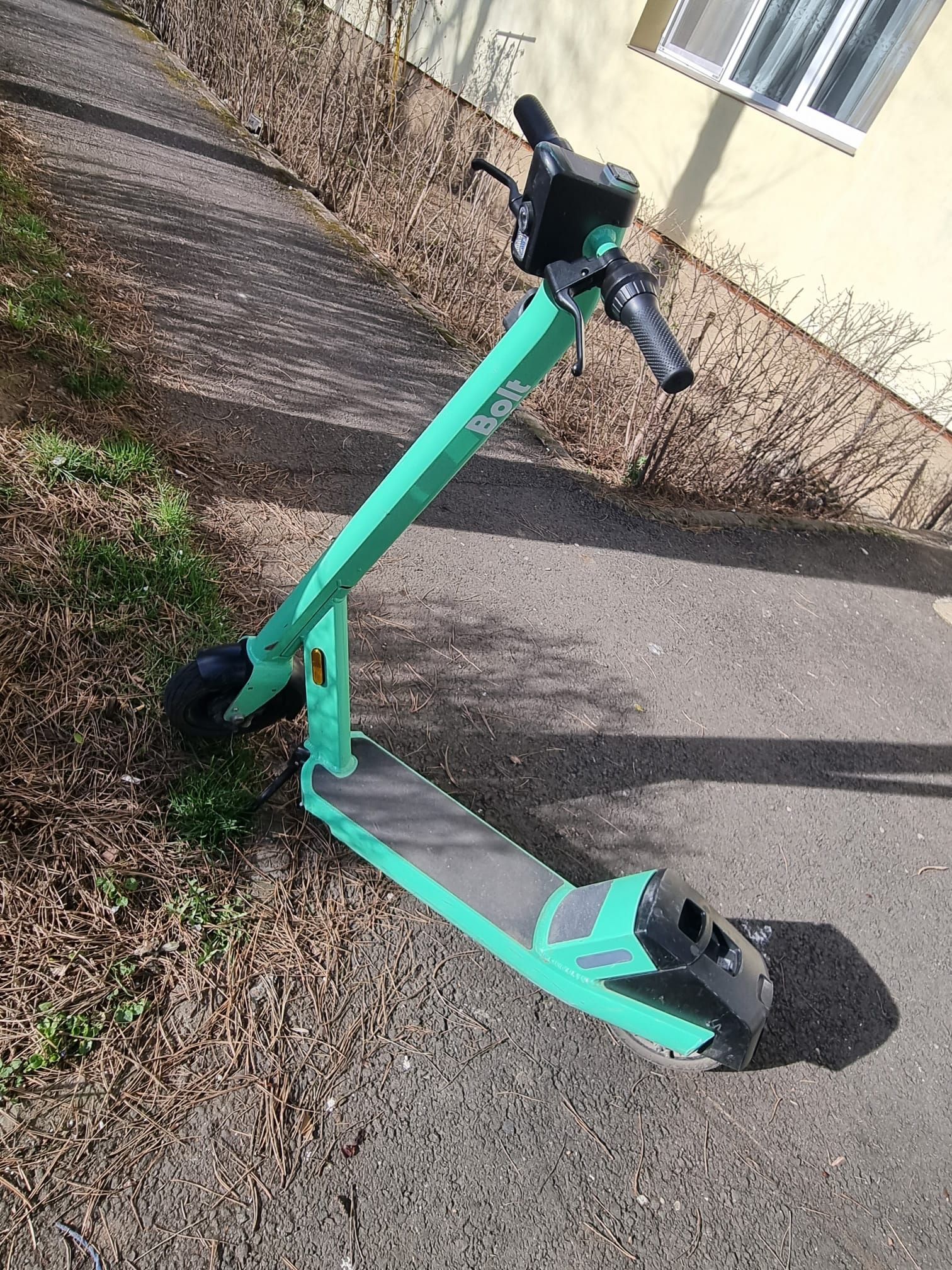 O trotinetă electrică Bolt parcată pe o stradă din Brașov.