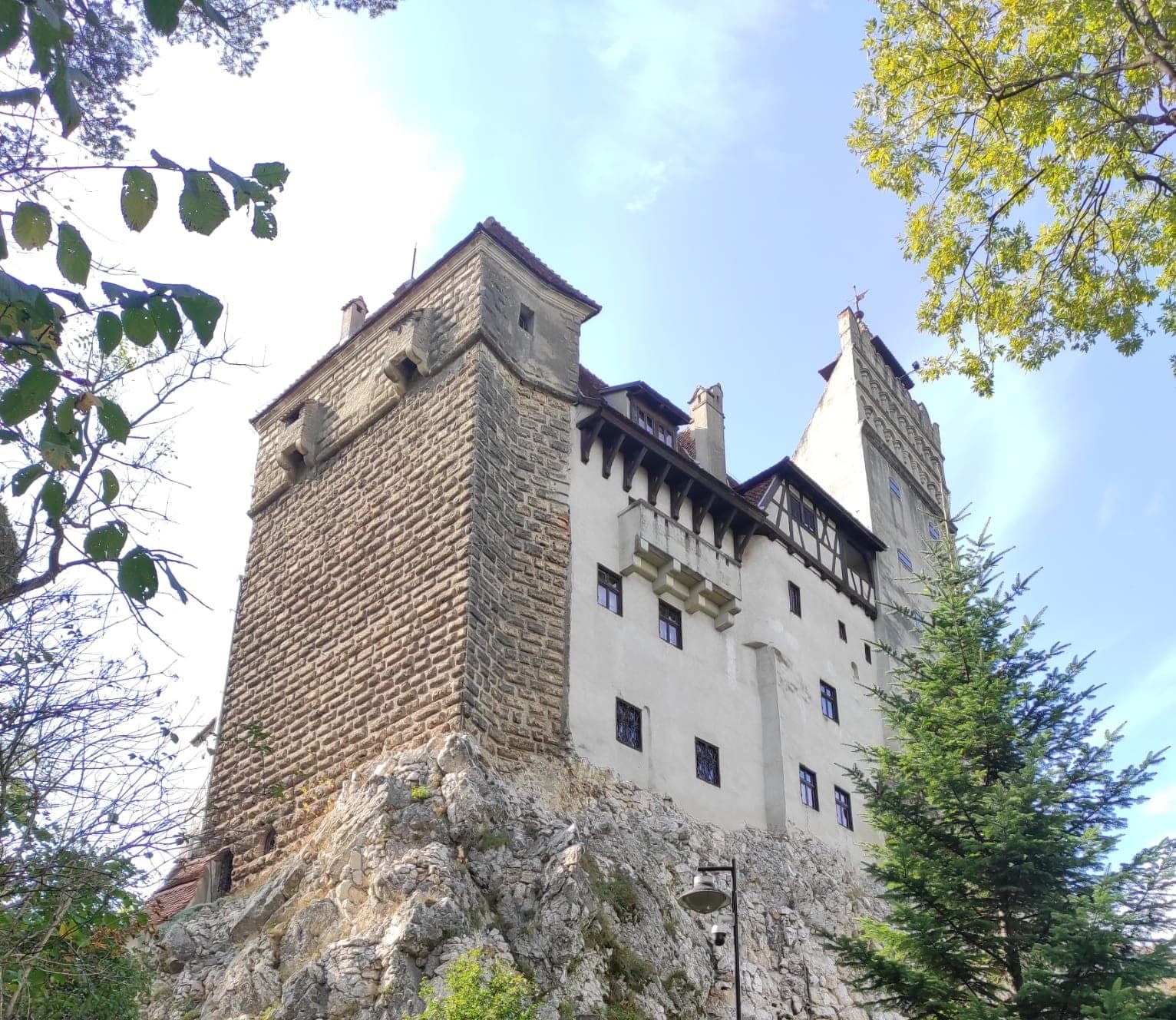 Castelul Bran pe stâncă, încadrat de copaci