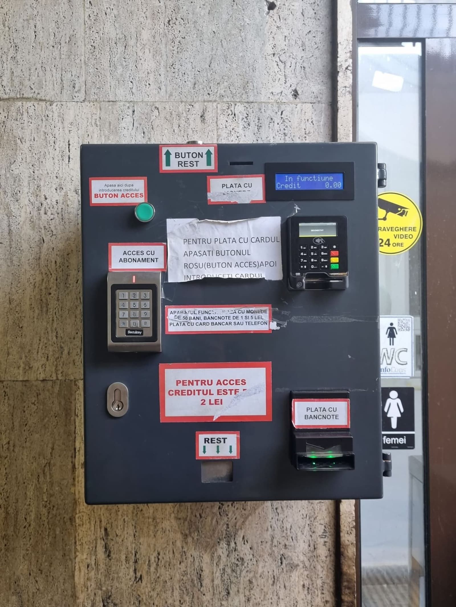 Macchinetta di pagamento con fessura per monete in un bagno pubblico di Brașov