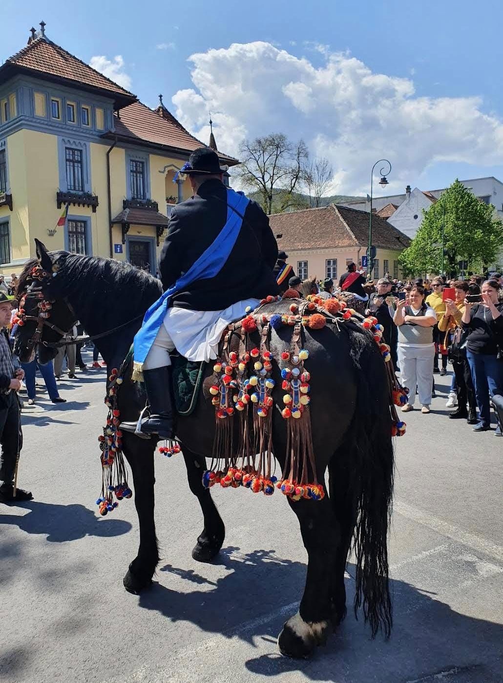 Junii Brașovului riders carrying traditional flags along Republicii Street