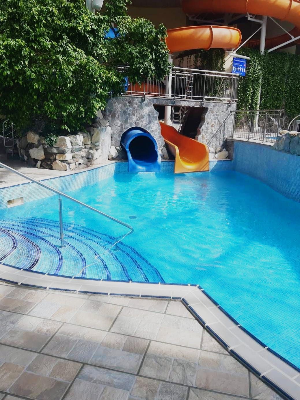 Piscină exterioară cu tobogane portocalii și albastre la Paradisul Acvatic