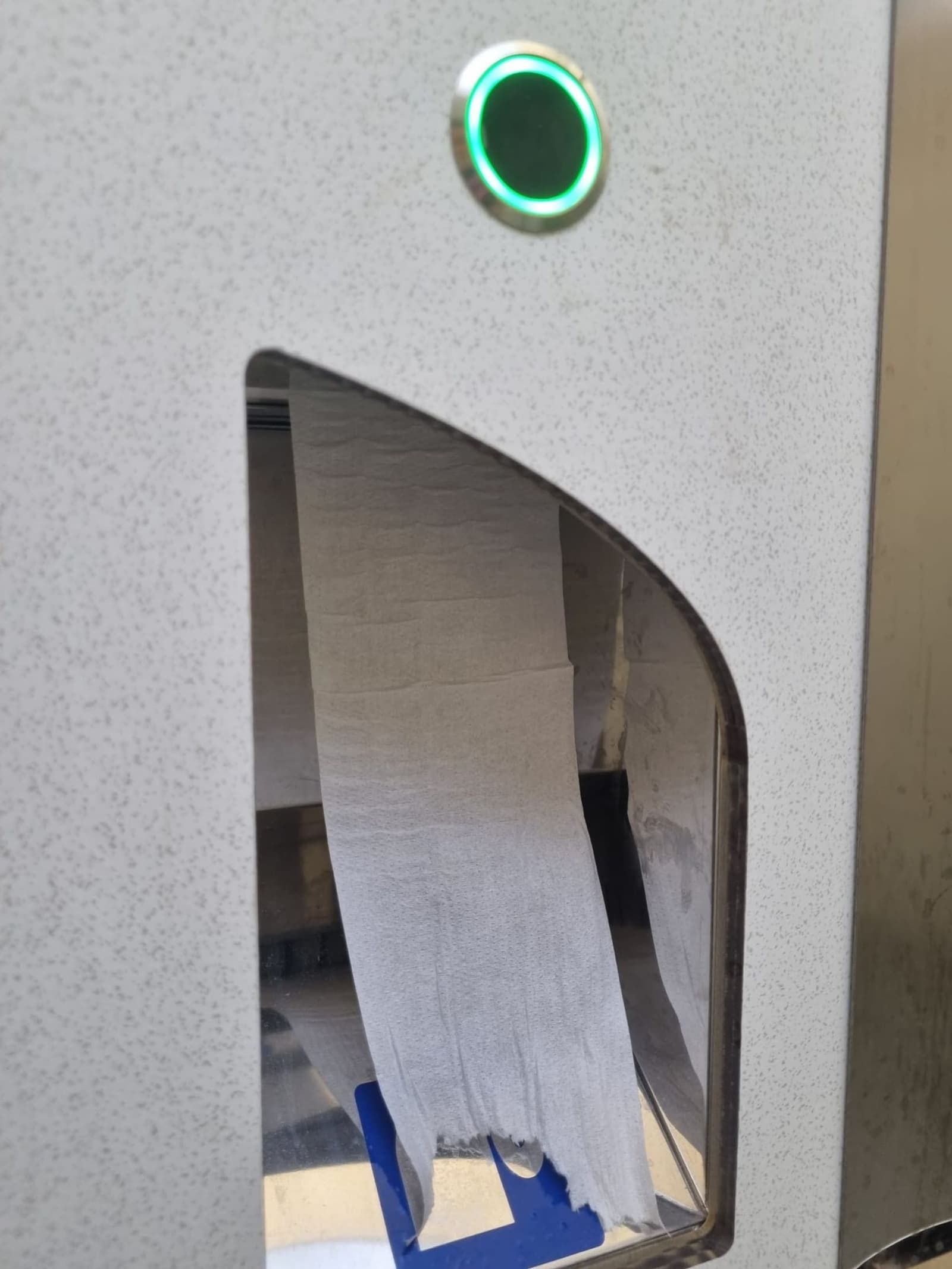 Distributore di carta igienica con sensore verde in un bagno smart