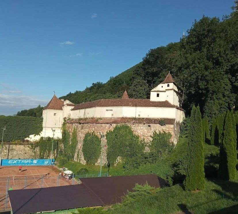 Zidurile albe și turnurile Bastionului Țesătorilor la poalele Tâmpei